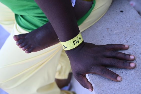 Il dettaglio di una mano di una giovane madre vicino ai piedi del suo bambino