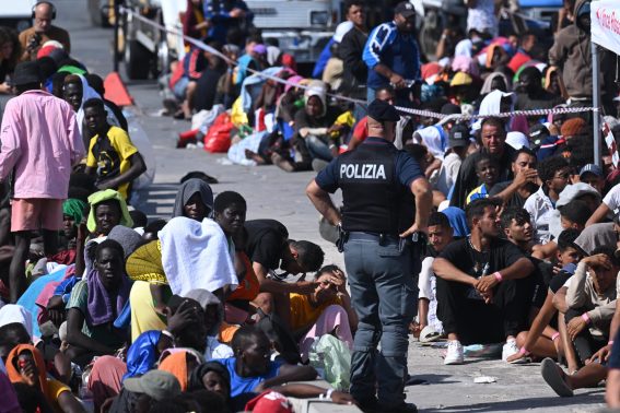 I migranti sbarcati a Lampedusa aspettano di essere controllati e poi trasferiti