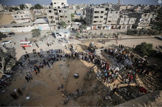 Palestinesi cercano corpi tra le macerie di un edificio raso al suolo nel campo profughi di Khan Younis
