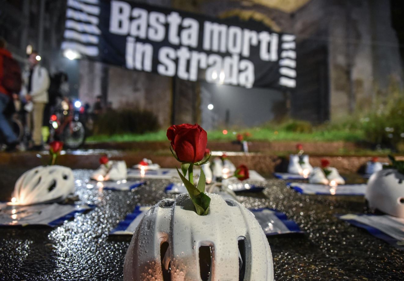 Caschi di ciclisti deceduti per strada, manifesti e candele per il flash-mob a Milano