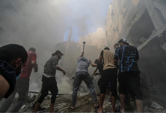 Persone cercano sopravvissuti sul luogo di un attacco missilistico israeliano nel campo profughi di Al-Shati