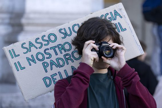 Un manifestante scatta una foto durante la protesta di Roma