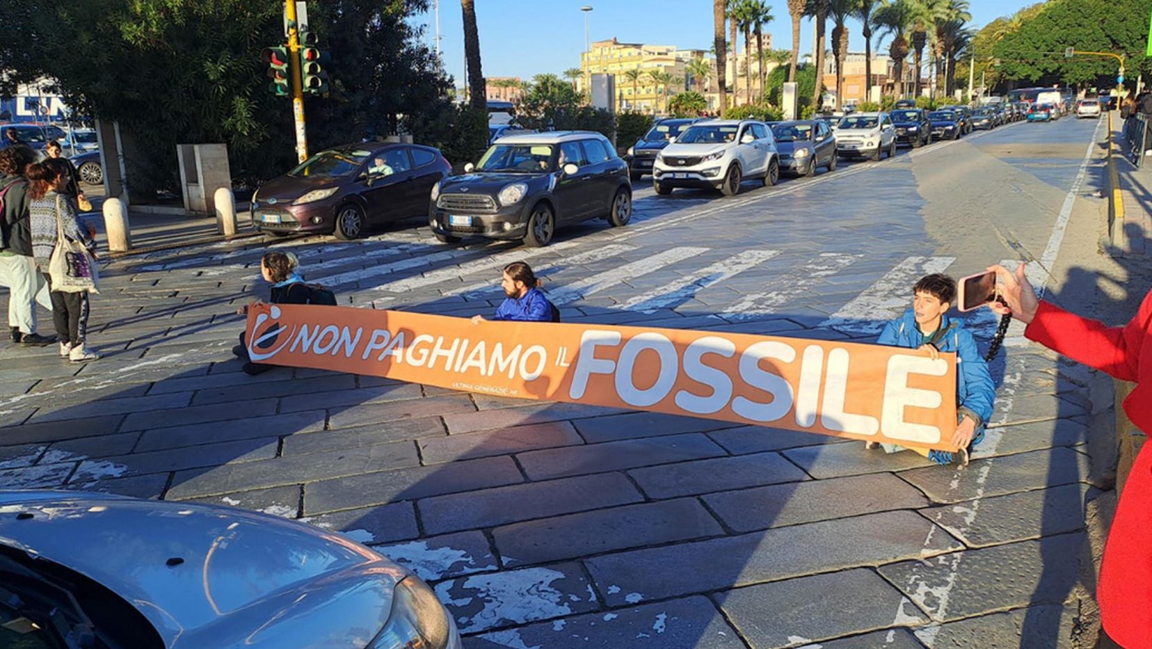 Gli attivisti di Ultima Generazione bloccano la strada principale di Cagliari con striscione "Non paghiamo il fossile" Gli attivisti di Ultima Generazione bloccano la strada principale di Cagliari con striscione "Non paghiamo il fossile"