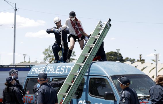 Una manifestante protesta sopra un furgone con la scritta "Free Palestine"