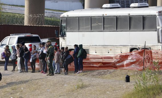 Un gruppo di migranti aspetta il proprio turno prima di salire su un autobus a Shelby Park a Eagle Pass, Texas, USA