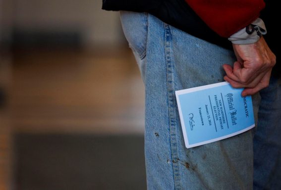 Un residente di Francestown tiene in mano la sua scheda elettorale nella sala del municipio