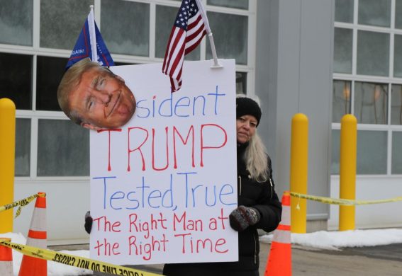 Una sostenitrice di Trump con un cartello pro-Donald davanti ad un seggio elettorale a Littleton