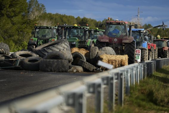 Balle di fieno e ruote di trattori bloccano l'autostrada AP-7 durante le proteste degli agricoltori