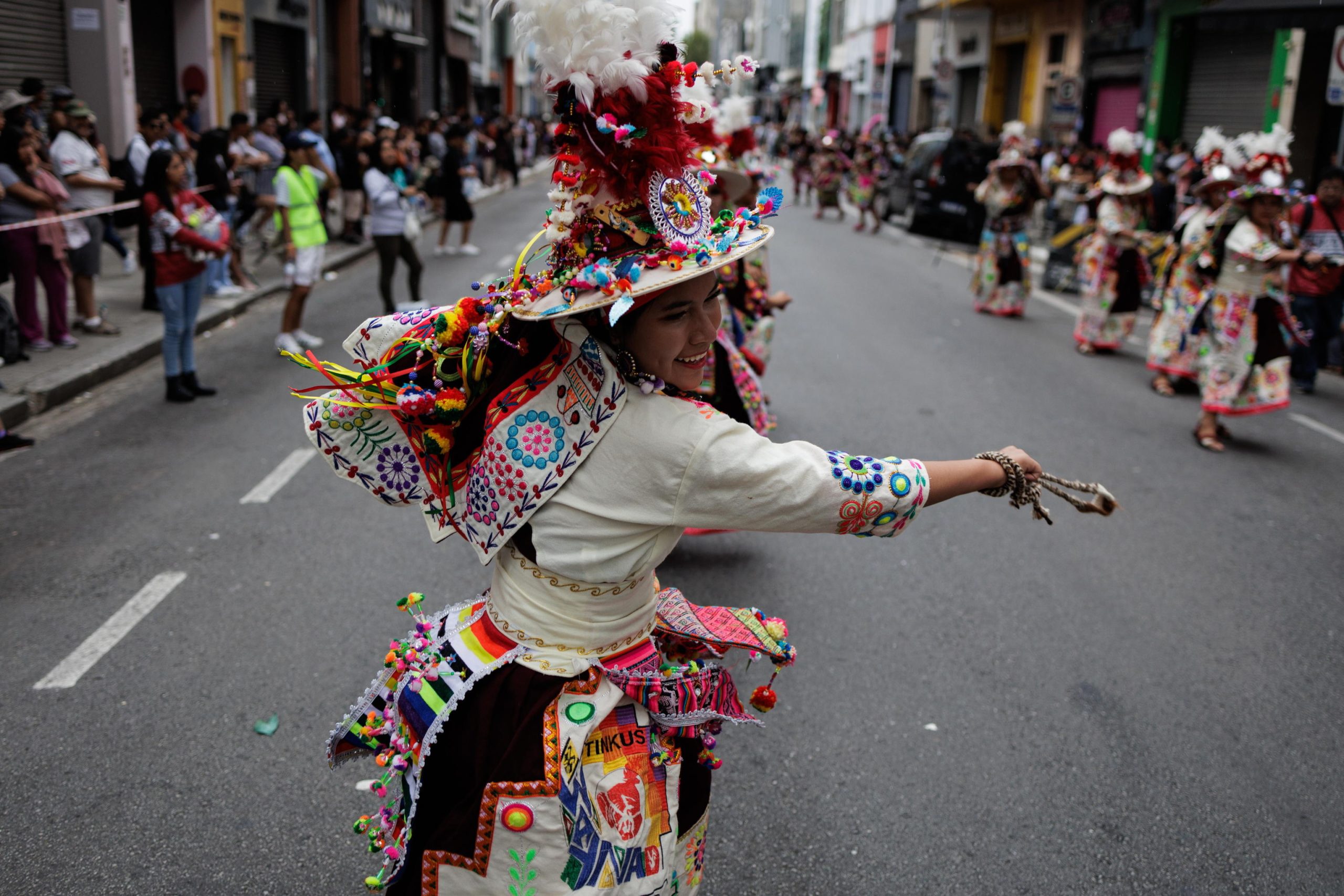 Una ballerina boliviana fa vorticare i pendenti colorati che ornano il suo costume