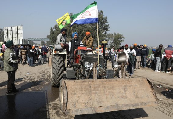 Agricoltori del Punjabi tengono bandiere seduti in cima al loro veicolo durante la protesta Agricoltori del Punjabi tengono bandiere seduti in cima al loro veicolo durante la protesta