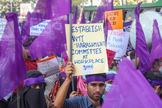 Un uomo mostra un cartello con la scritta "Istituire un comitato contro le molestie sul posto di lavoro" durante le celebrazioni della Giornata internazionale della donna, a Dhaka, in Bangladesh.