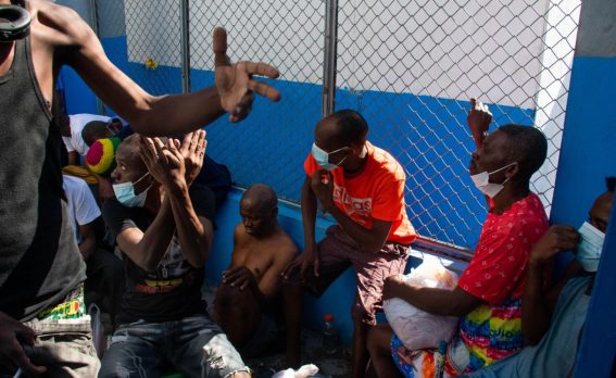 Detenuti riposano all'interno di una zona del penitenziario nazionale haitiano, dopo l'attacco da parte di bande armate