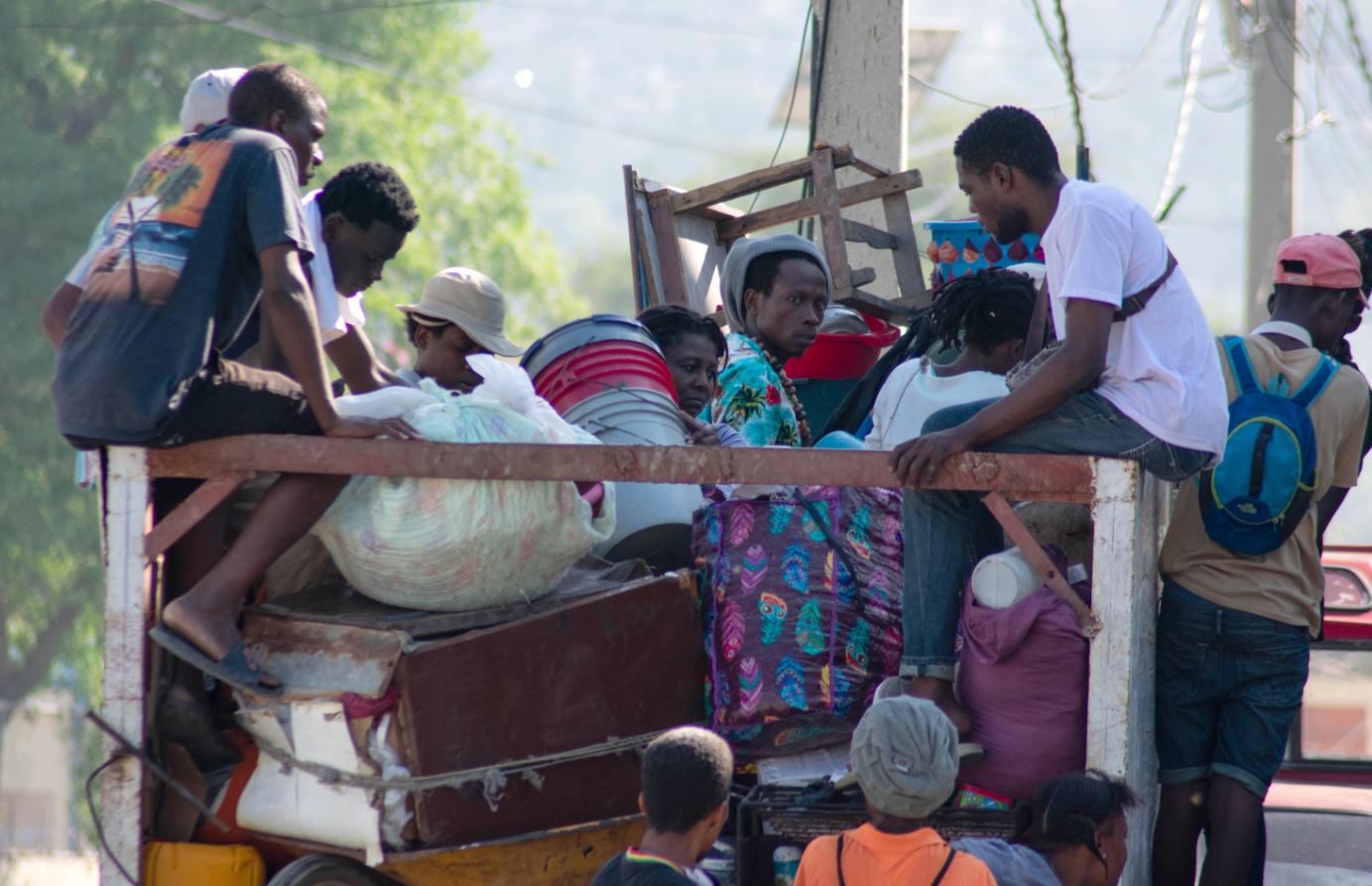 Persone trasportano le loro cose durante i disordini civili in corso nel centro della città