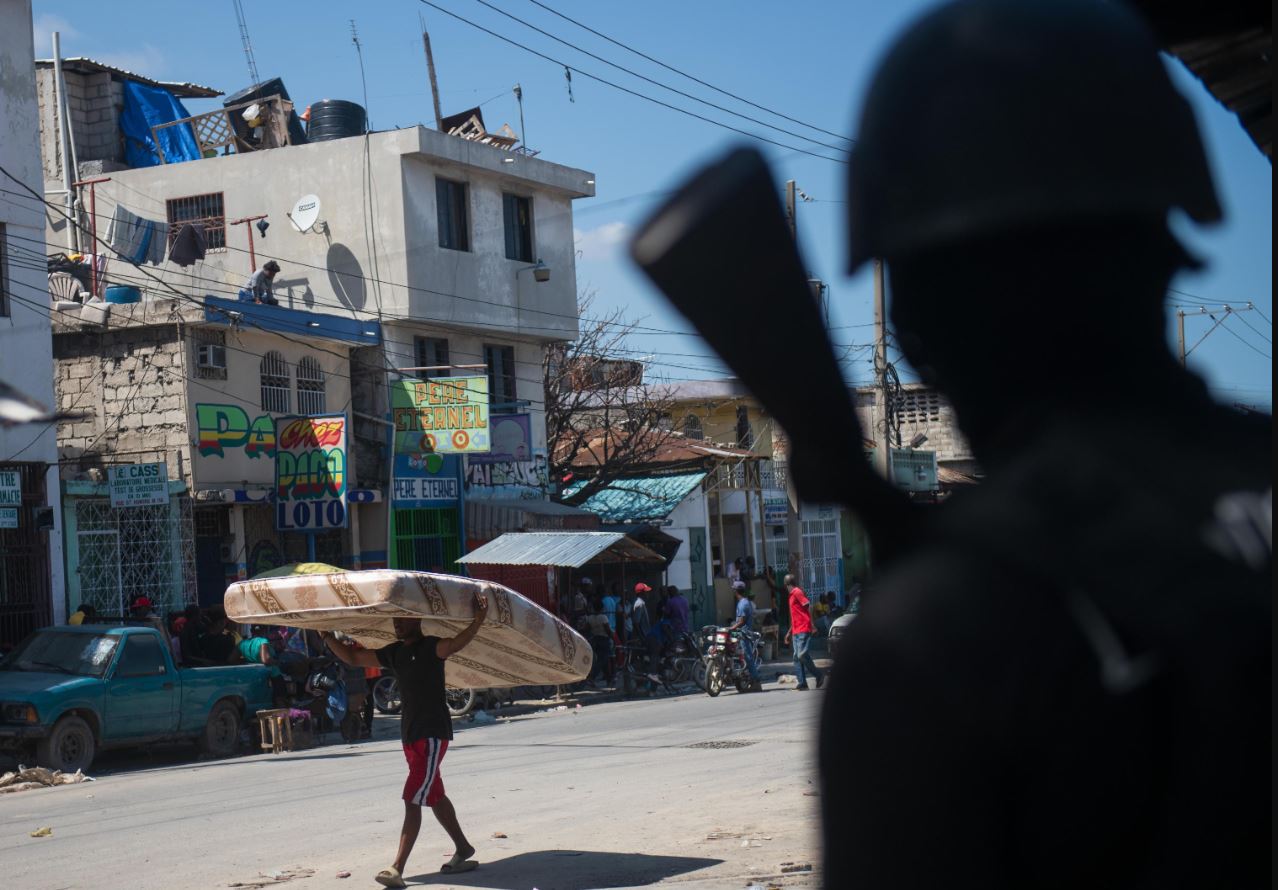 Un poliziotto vigila su Port-au-Prince dopo che la violenza di gruppo ha causato almeno cinque morti e venti feriti