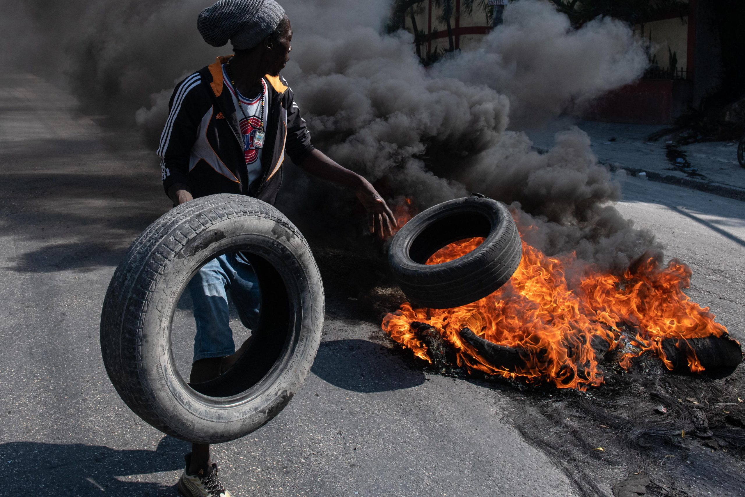Un manifestante dà fuoco a pneumatici durante la protesta a Port-au-Prince Un manifestante dà fuoco a pneumatici durante la protesta a Port-au-Prince