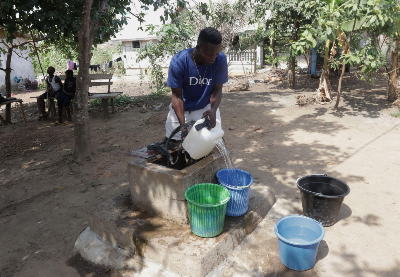 Jeferry Joe attinge acqua da un pozzo nella comunità di Ben's Town, Liberia