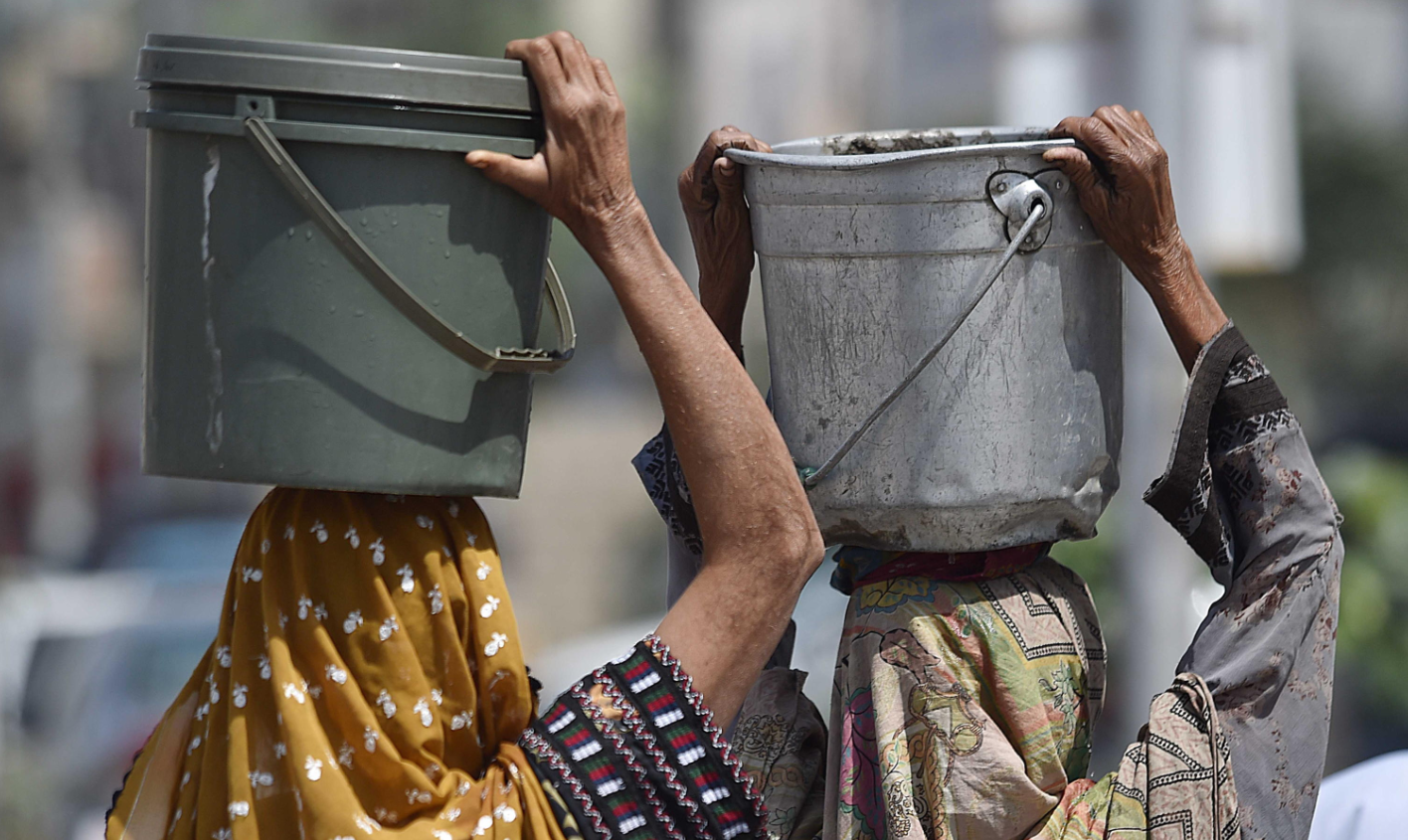 Due donne portano a casa l'acqua potabile a Karachi, in Pakistan