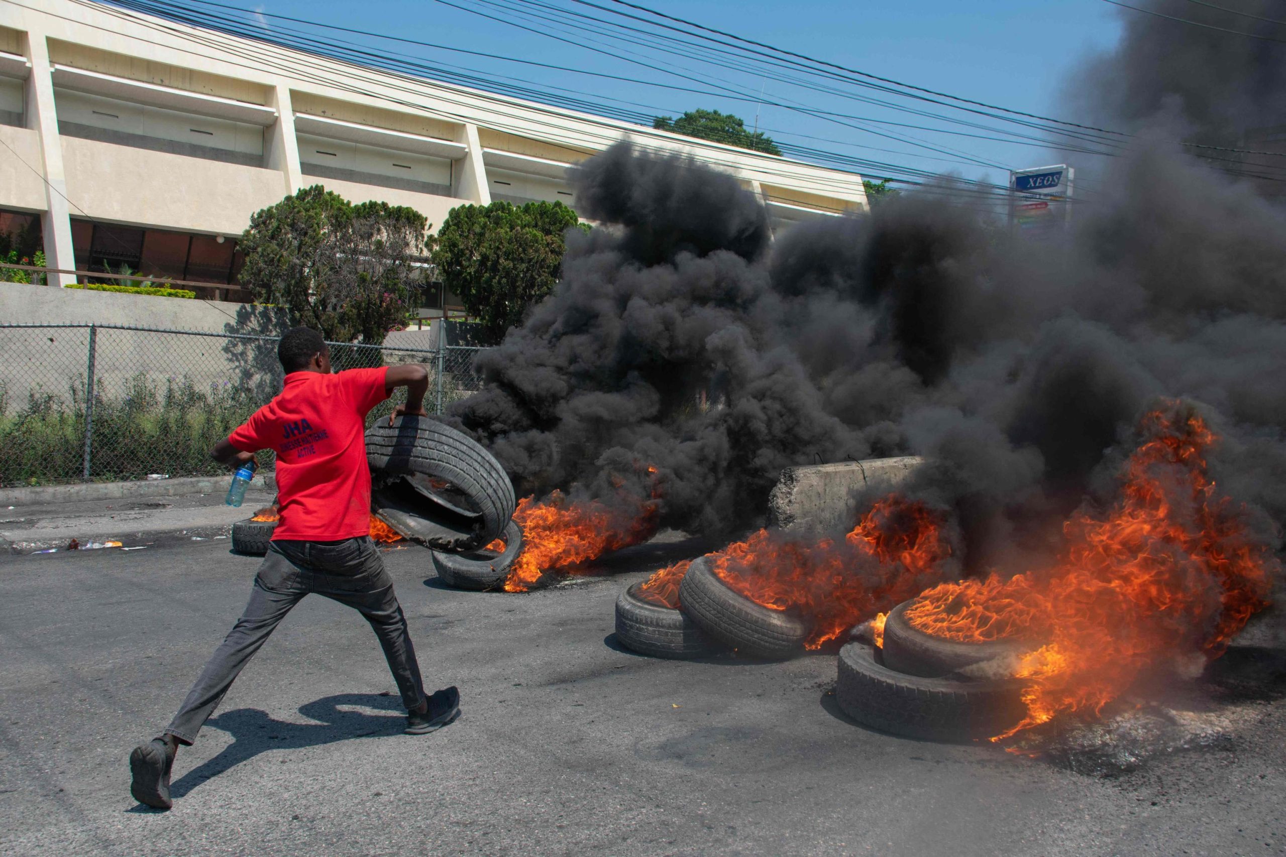 Un manifestante brucia pneumatici durante una protesta a Port-au-Prince, Haiti, in seguito alle dimissioni del premier Henry Un manifestante brucia pneumatici durante una protesta a Port-au-Prince, Haiti, in seguito alle dimissioni del premier Henry