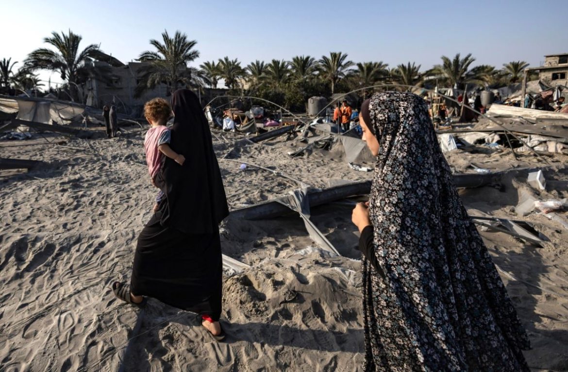 In primo piano due donne palestinesi alla ricerca delle persone scomparse a seguito di attacchi aerei israeliani su una zona umanitaria designata di Al-Mawasi | foto Ansa