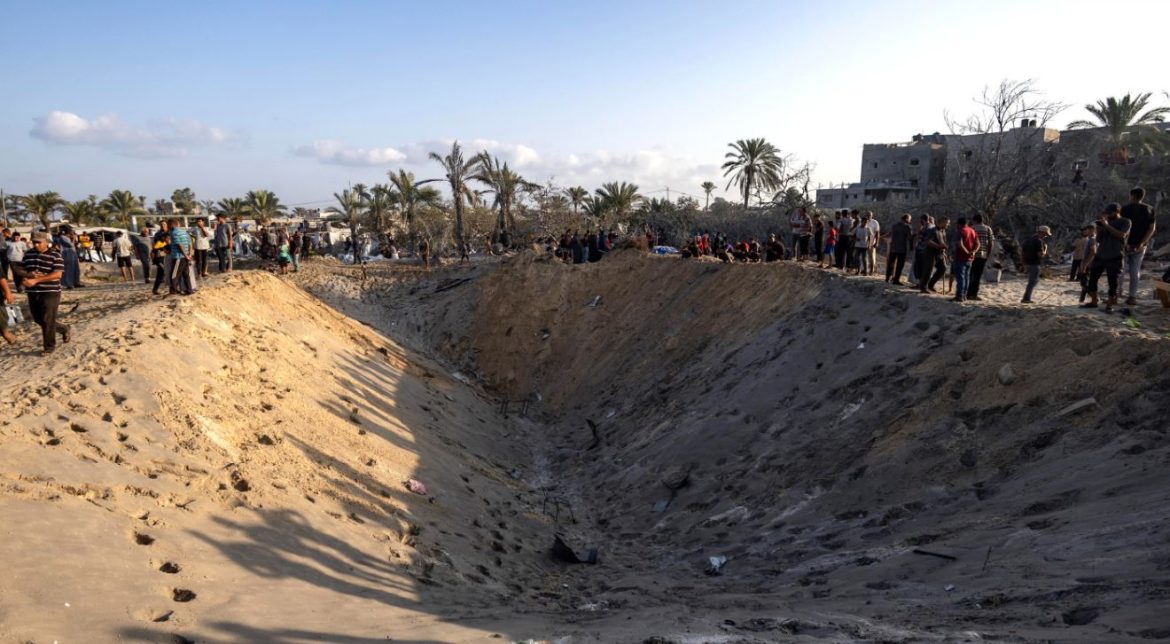 I rifugiati ispezionano un cratere causato dall'esplosione di uno dei quattro missili israeliani | foto Ansa