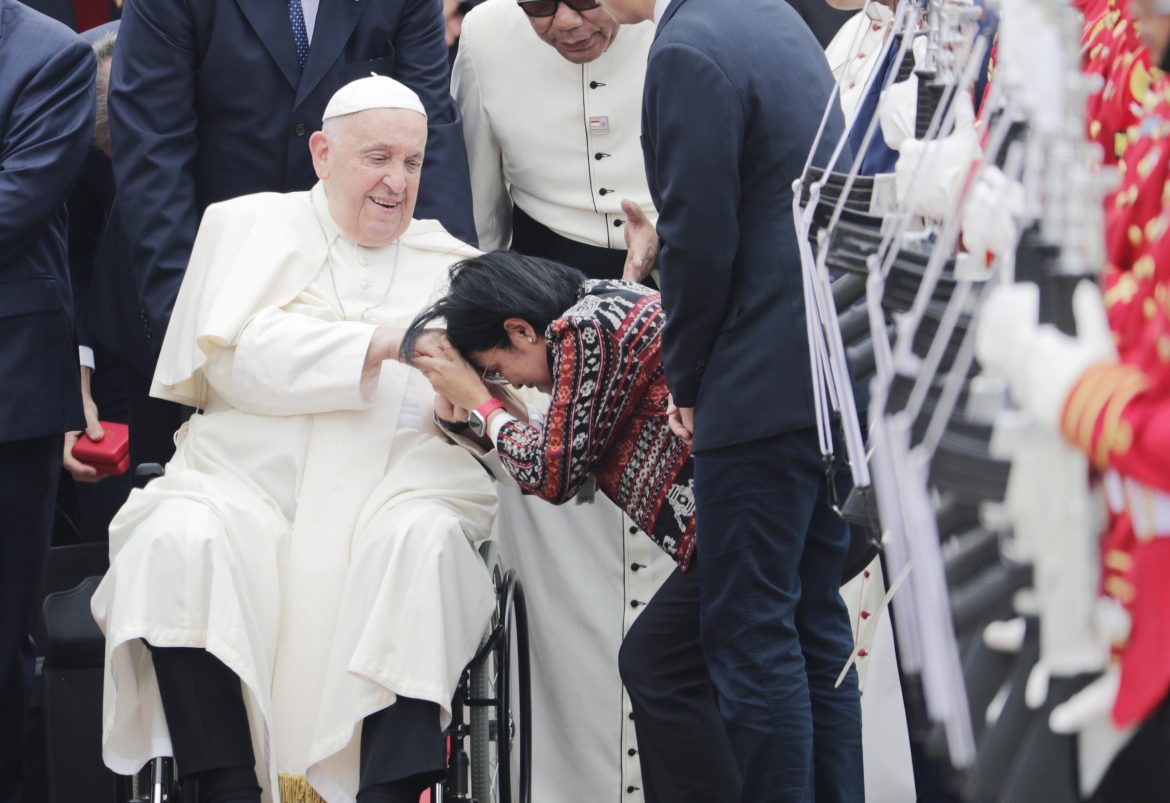 Una donna indonesiana accoglie il Papa subito dopo l’atterraggio