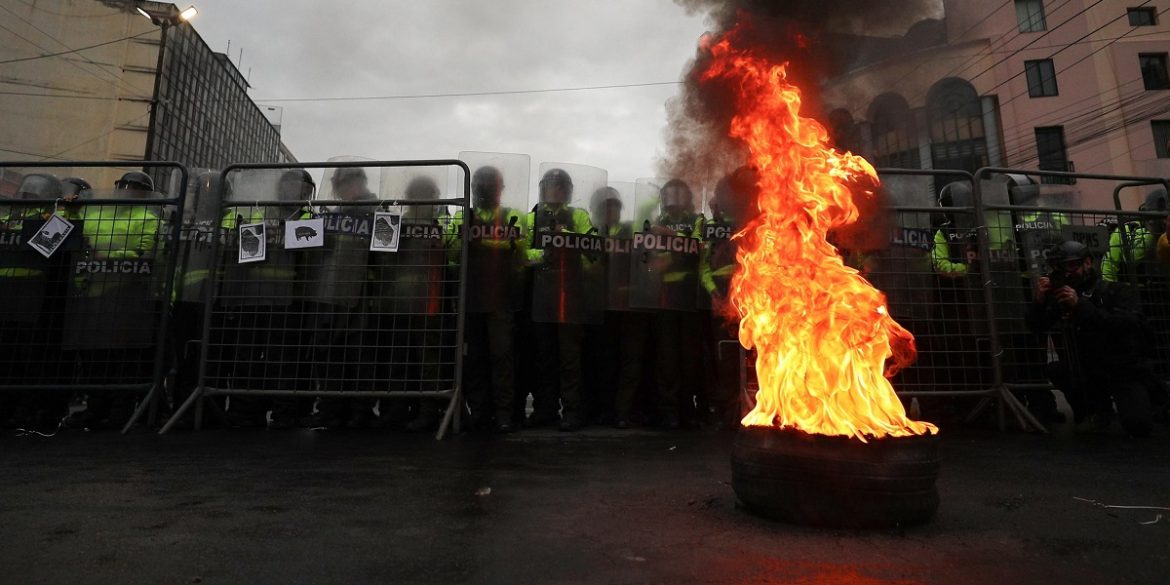 Ecuador-11 Agenti della polizia ecuadoregna in blocco di fronte a degli pneumatici dati alle fiamme durante la marcia di protesta | Foto Ansa