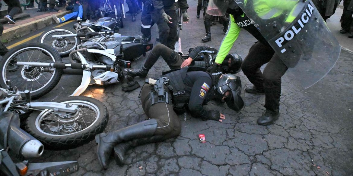 Ecuador-7 Un agente aiuta un collega ferito durante gli scontri avvenuti durante la marcia di protesta indetta dalle unioni sindacali e i gruppi sociali contro il governo Daniel Noboa a Quito, la capitale | Foto Ansa