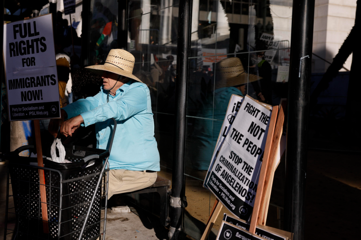 LA 3 Un uomo circondato da cartelli che chiedono il rispetto per i diritti degli immigrati, durante le manifestazioni a Los Angeles