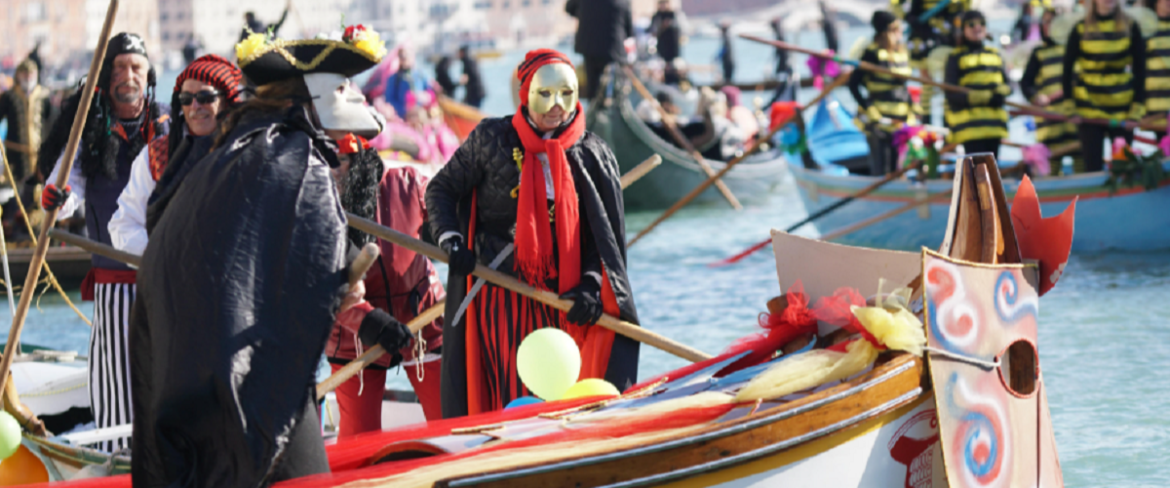 Due vogatori travestiti che remano sulle tradizionali imbarcazioni | Foto Ansa Due vogatori travestiti che remano sulle tradizionali imbarcazioni | Foto Ansa