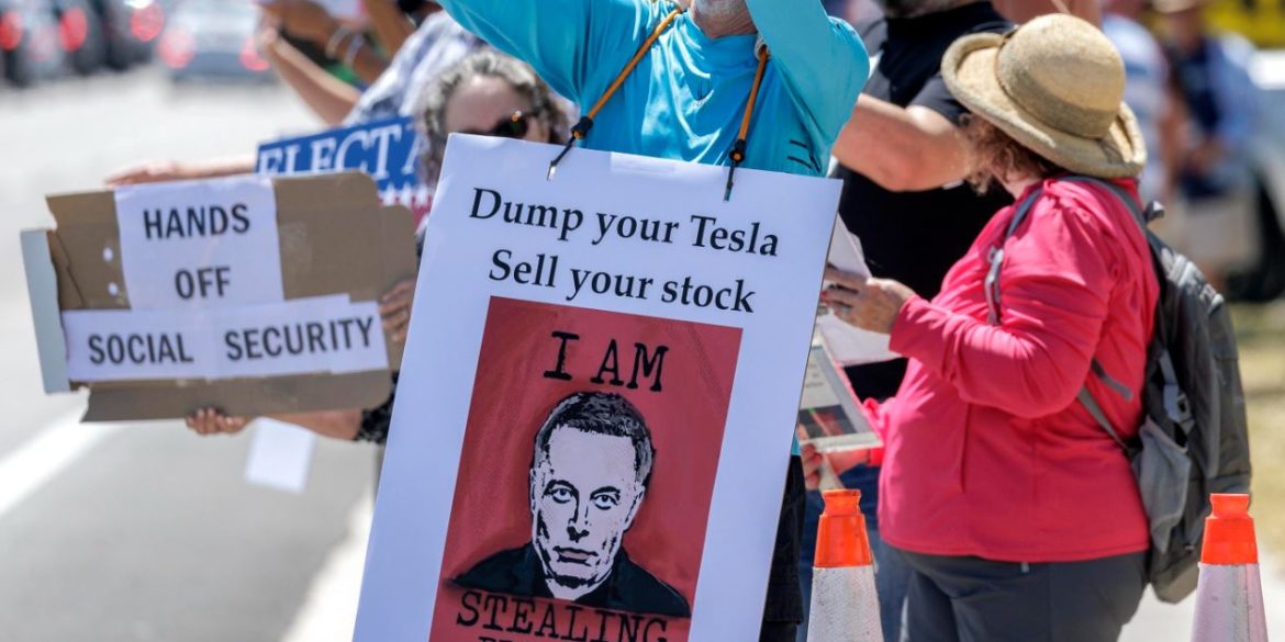 Attivisti partecipano alla protesta “Tesla Takedown” davanti a uno showroom della società automobilistica a Fort Lauderdale, in Florida