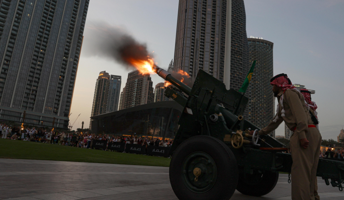 Dubai Un militare arabo spara un colpo di cannone a salve che sancisce la fine del giorno di digiuno di fronte al Burj Khalifa, Dubai, Emirati Arabi Uniti