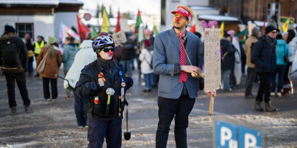 Manifestanti travestiti da Donald Trump e polizia partecipano alle proteste davanti per le strade di Davos, Svizzera
