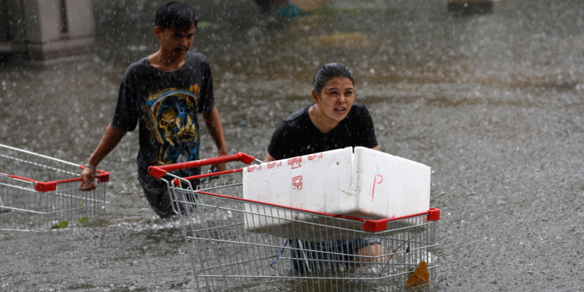 carrelli Una donna thailandese spinge un carrello della spesa dopo aver acquistato del cibo | Foto Ansa