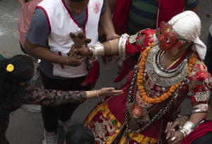 I partecipanti al Naradevi Dance festival in Nepal esprimono gesti di adorazione verso un uomo travestito con la maschera della divinità