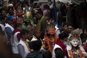 Uomini nepalesi indossano maschere religiose per partecipare alla manifestazione del Naradevi Dance festival