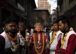 Un uomo, aiutato dai giovani parenti, partecipa al Naradevi Dance festival indossando le tradizionali maschere religiose