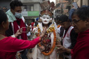  I devoti venerano un uomo che indossa una maschera religiosa adornandolo con collane durante il Naradevi Dance festival