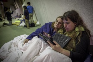 Due donne evacuate per il collasso della diga di Oreville guardano il pc.