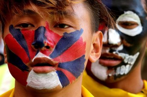 La bandiera tibetana dipinta sul volto di un manifestante