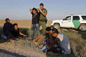 Un agente interroga e perquisisce delle persone sospettate di voler attraversare il confine Usa-Mexico, vicino McAllen, Texas. 