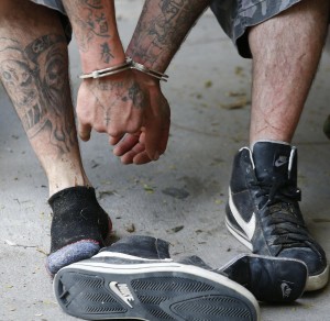 Dettaglio mani e piedi di un uomo fermato perché sospettato di voler attraversare il confine. 