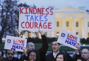 Partecipanti alla protesta mostrano cartelli contro Trump