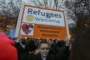 Una ragazza solleva uno striscione a favore dei rifugiati