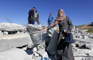 Taghrid e la sua famiglia mostrano quello che resta della loro casa, abbattuta questa mattina dalle ruspe dell’esercito israeliano.
