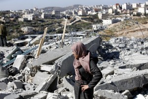 Taghrid, proprietaria dell'abitazione di Hebron demolita dagli israeliani, guarda gli effetti della distruzione.