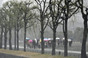 Turisti a Tokyo si riparano dalla neve