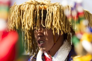Un uomo con il tradizionale copricapo tibetano durante la preghiera