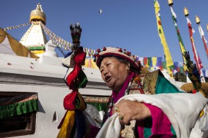 Una donna indossa il tradizionale abito tibetano durante la processione